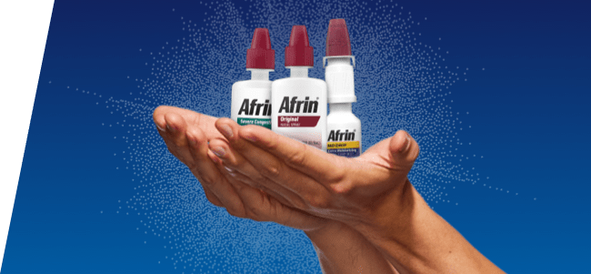 both hands holding Afrin nasal spray bottles on green background