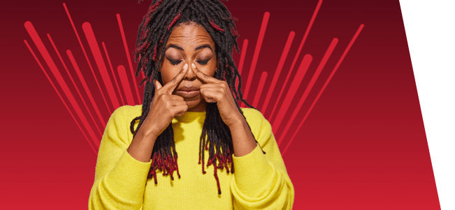 woman with nasal congestion touching nose with both pointer fingers on red background