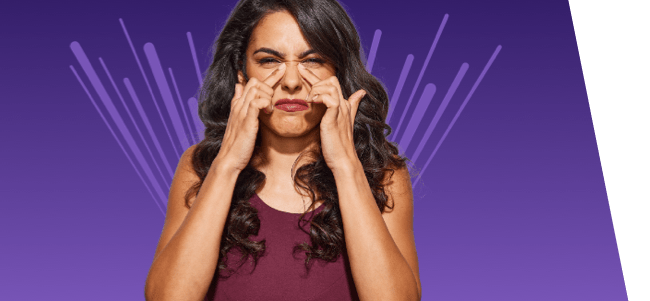 woman with nasal congestion touching nose with both pointer fingers on purple background